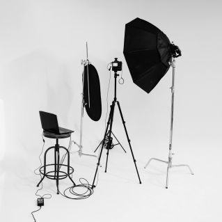 Black and white photo of a photography studio setup with lighting and camera gear.